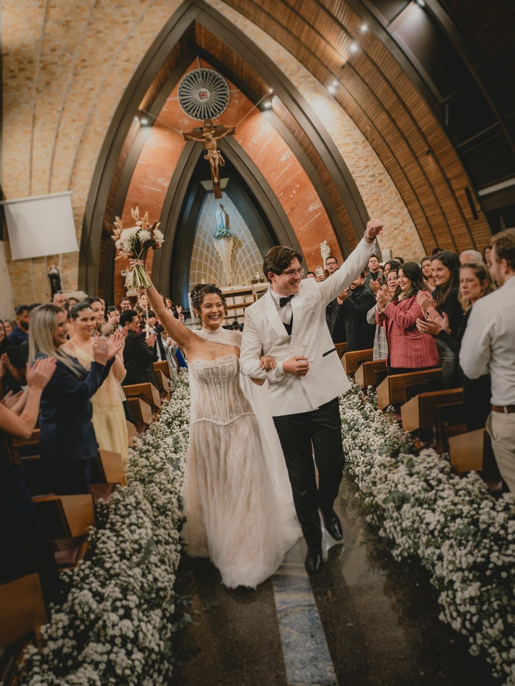 Saída dos noivos da igreja entre convidados